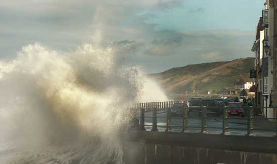 Sandsend with a high tide and crashing waves coming into the harbour wall