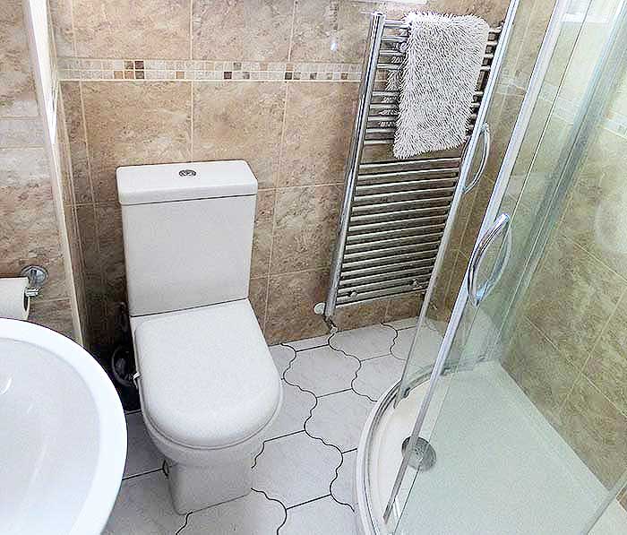 Bathroom with large shower cubicle and fully tiled
